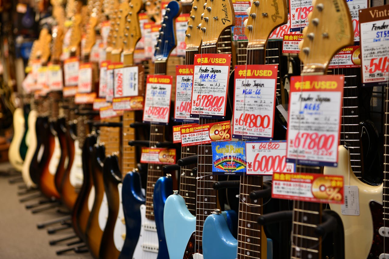 A vibrant display of used Fender guitars in a Tokyo shop, highlighting variety and pricing.